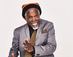 A smiling man in a grey suit 