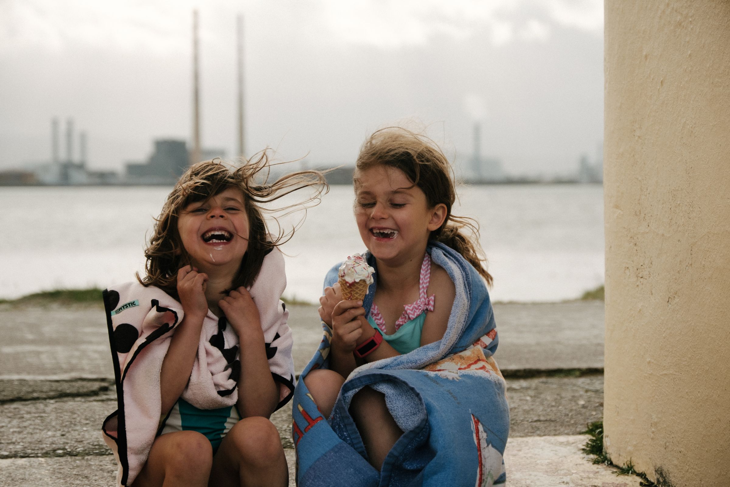 Two girls laughing and eating ice cream cones