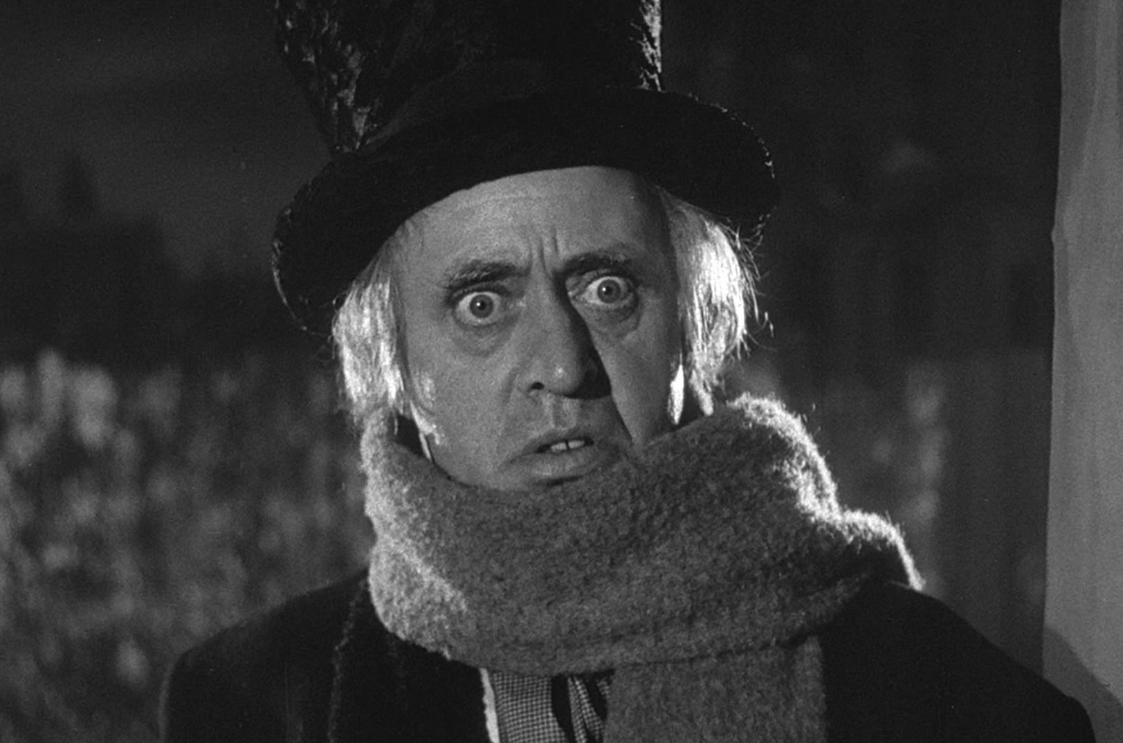 A frightened man in a top hat and scarf.