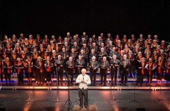 The Bray Community Choir on a large stage with conductor