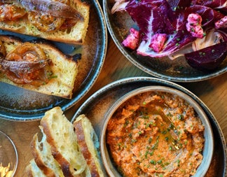 A selection of small plates with toasted bread and toppings 