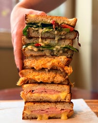 A selection of different toasted sandwiches stacked on top of each other