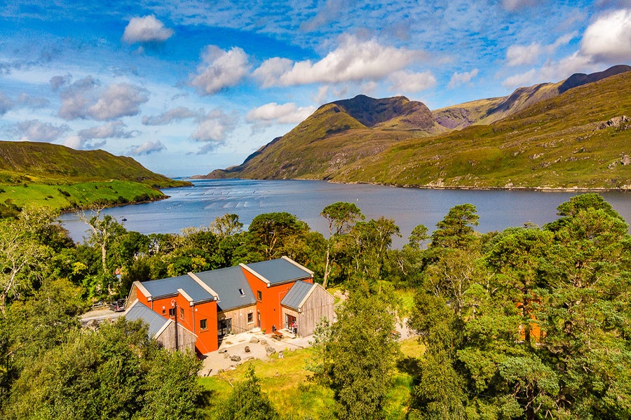 View of orange house with water and mountains in background