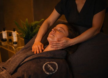 A guest enjoying a gentle facial massage in a softly lit treatment room.