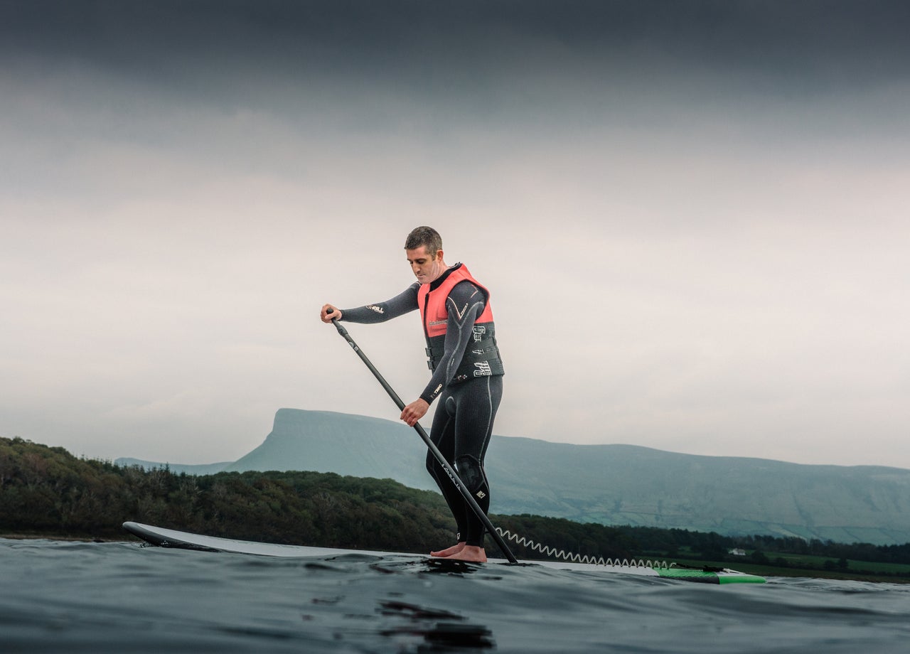 A man on the water stand up paddle boarding with Sligo Bay Sup
