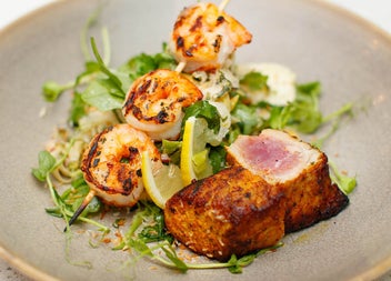 A plate of seared scallops and tiger prawn satay from the a la carte menu at Bay Restaurant