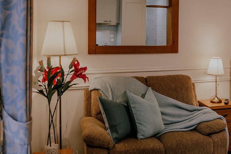 Orange couch with grey throws