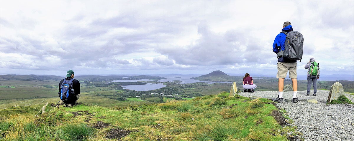 Beyond the Glass Eight Day Explorer Tour group on a hill overlooking scenic Connemara National Park