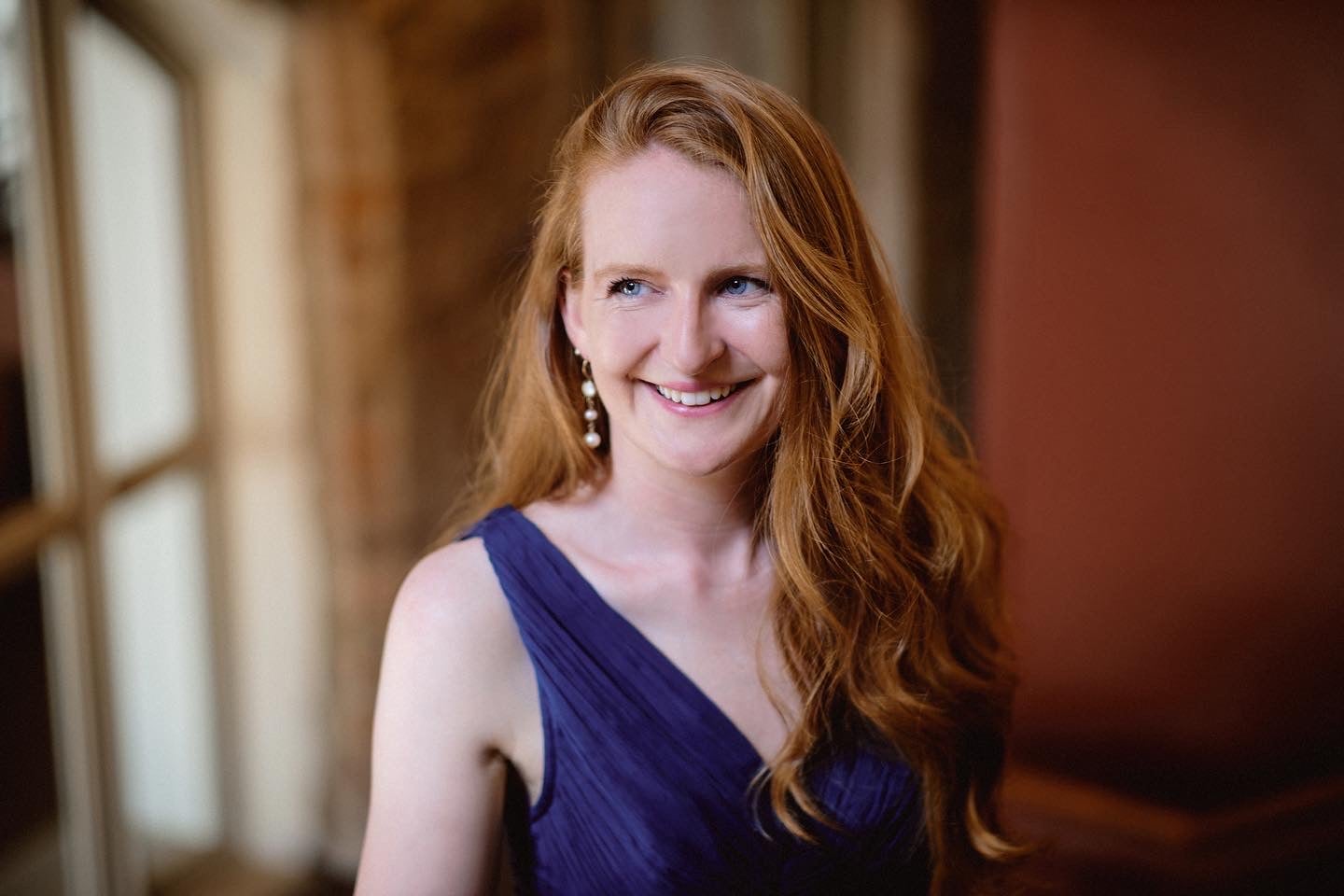 Aisling Kenny, soprano - a smiling woman with long hair in evening dress