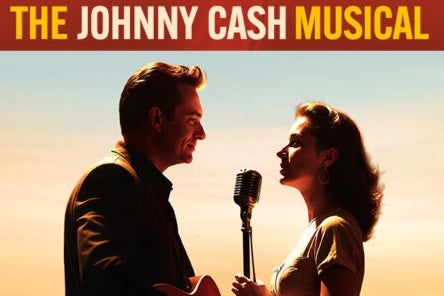 2 people viewed from the side singing into a mic on stand between them.