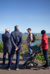 People and their tour guide looking at a coastal view