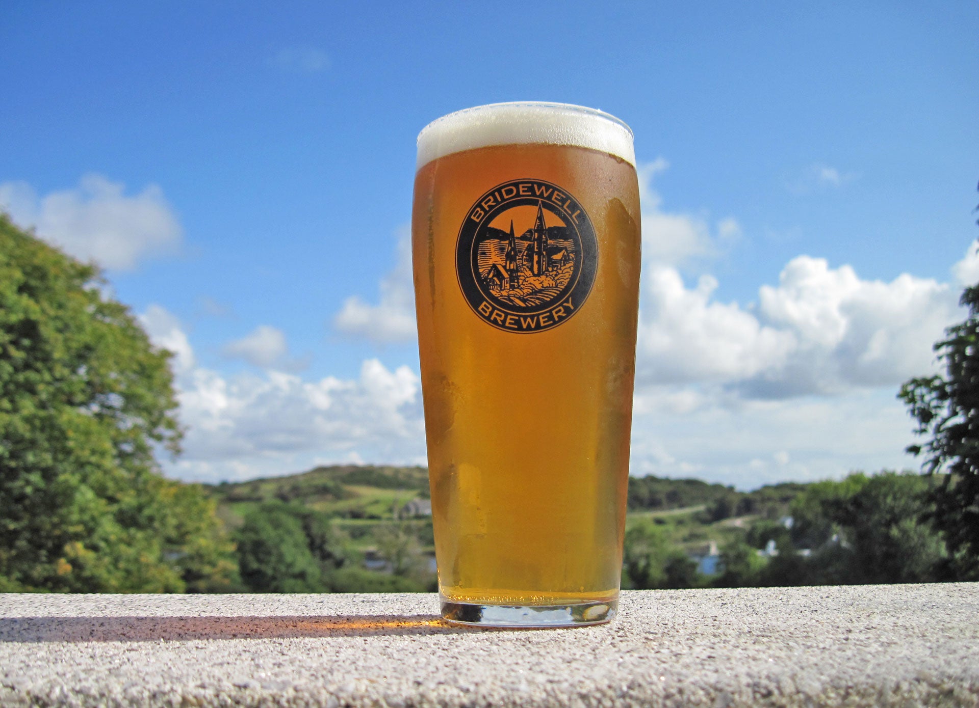 Bridewell Brewery pint of blond ale in the sunshine in front of Connemara hills