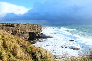 Image of waves crashing against cliff.