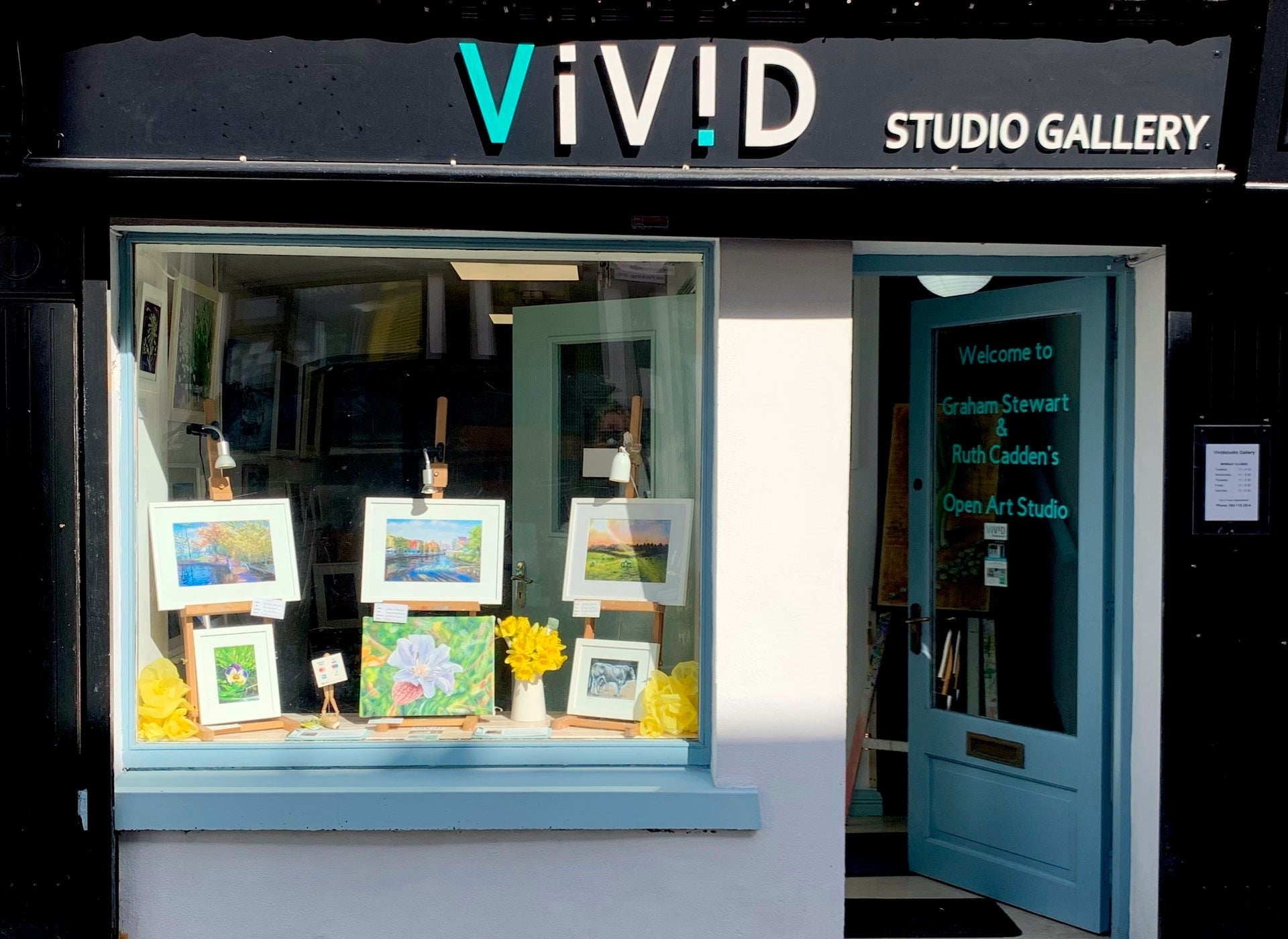 Shop front of Vivid Studio Gallery with paintings on display in window