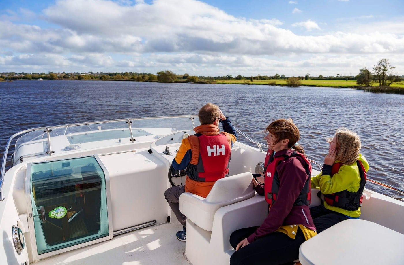 Three people on a cruiser on a river