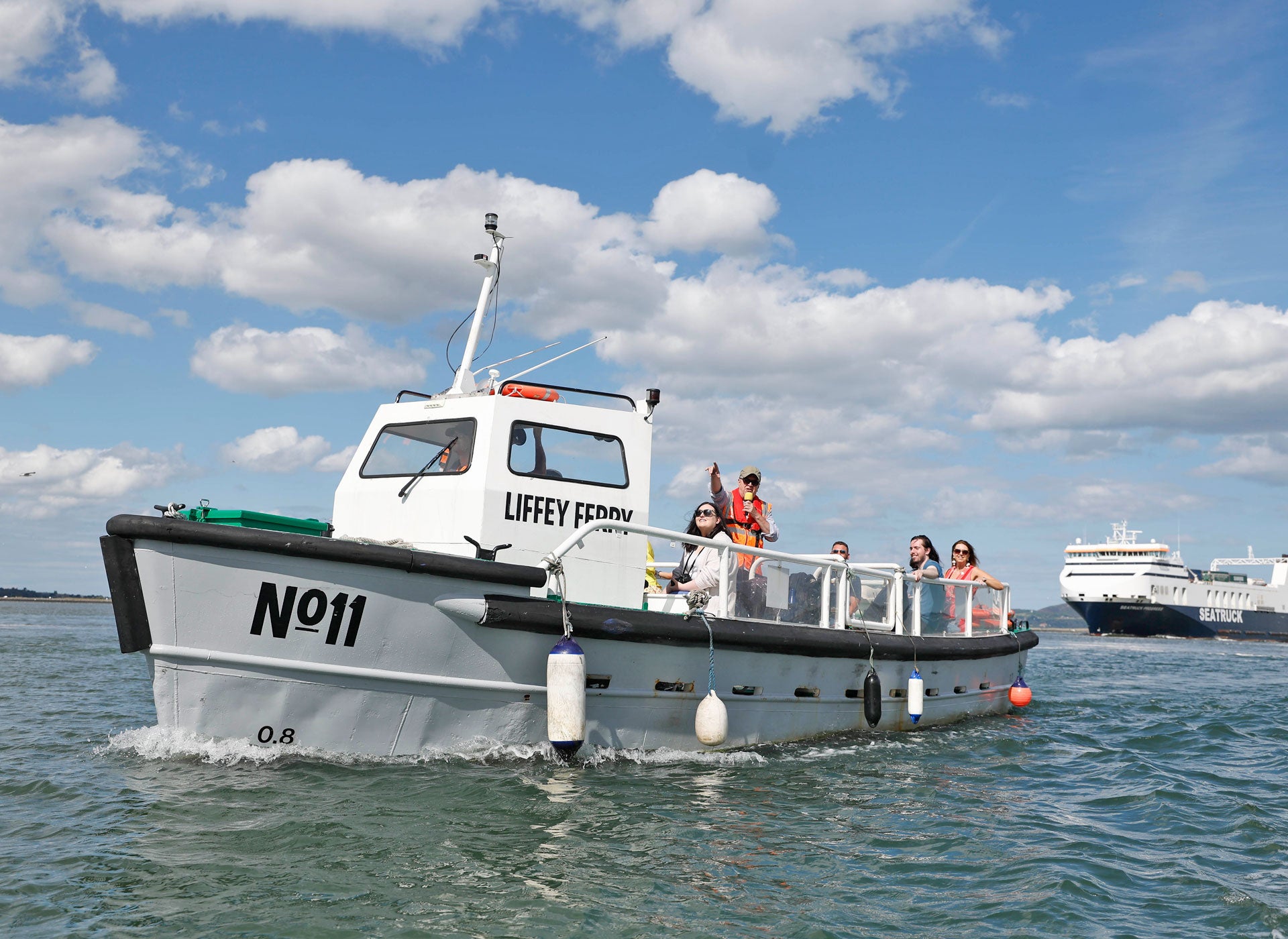 The Old Liffey Ferry number eleven on the water with people waving