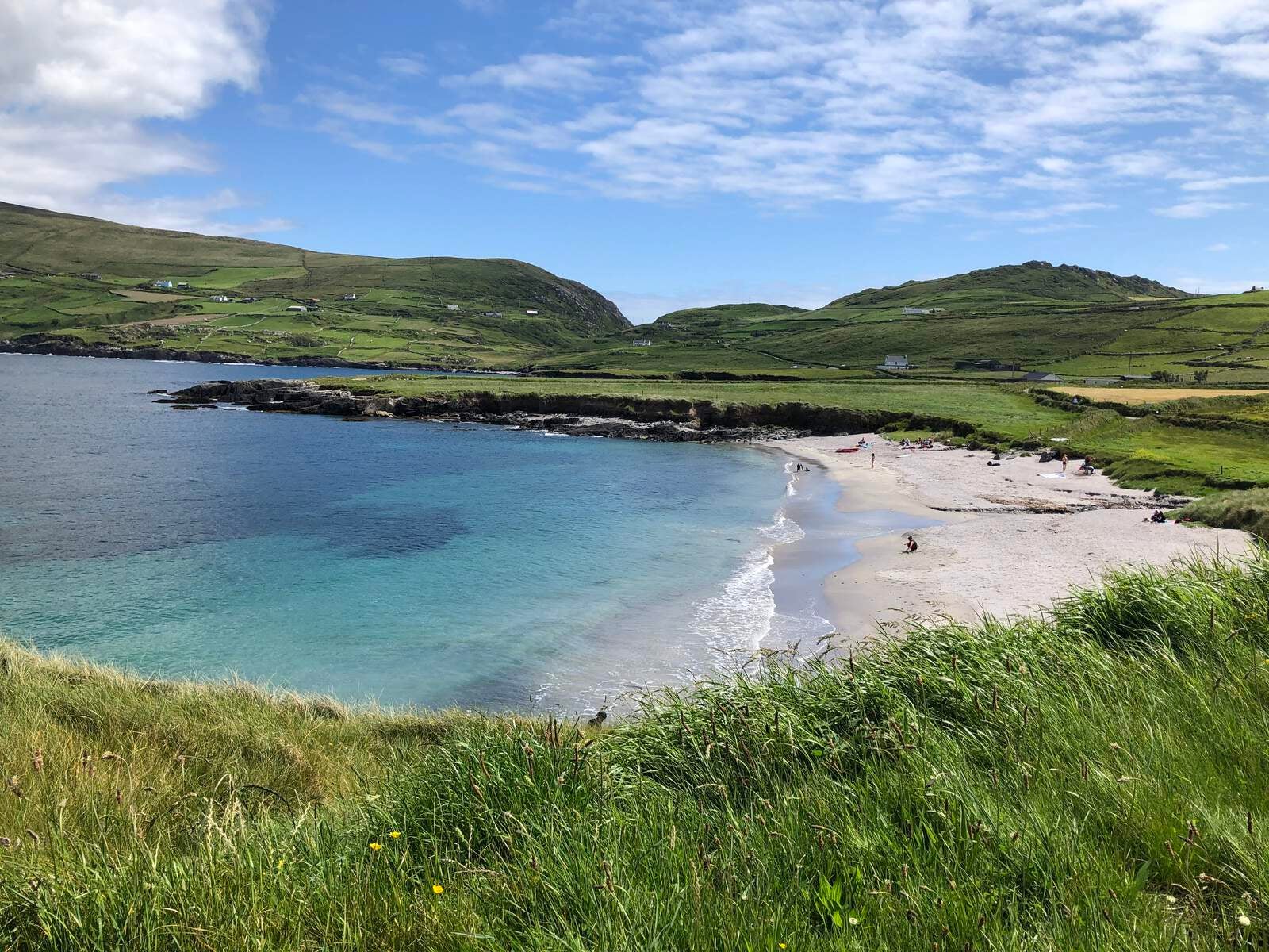 View towards a sandy beach with green hills in the background