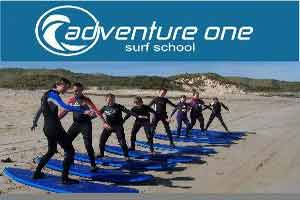 A group of people learning how to surf at Adventure One Surf School