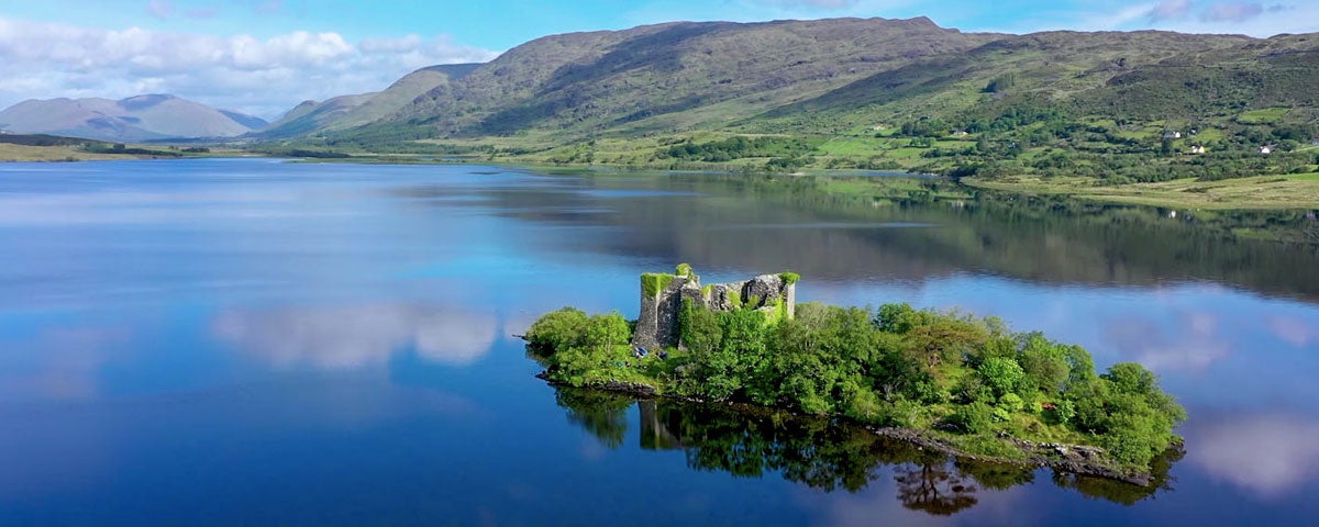 The ruins of a castle on a small island on a lake in Connemara