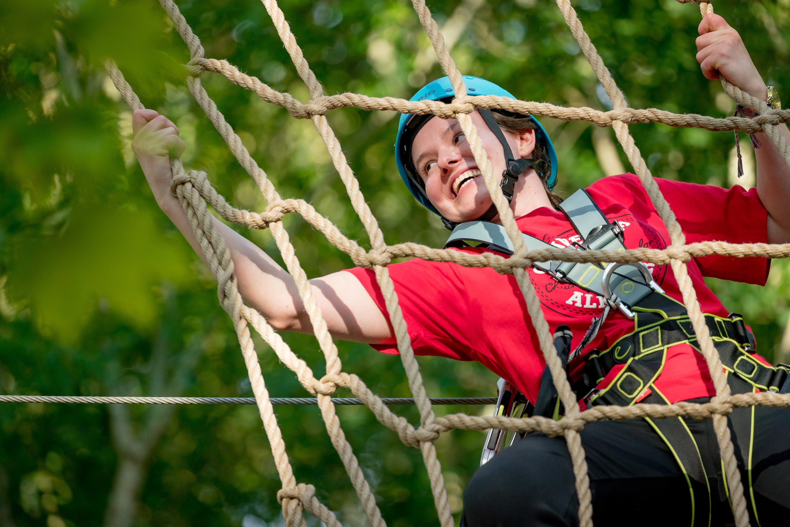 Young person climbing rope ladder in Castlecomer Discovery Park.