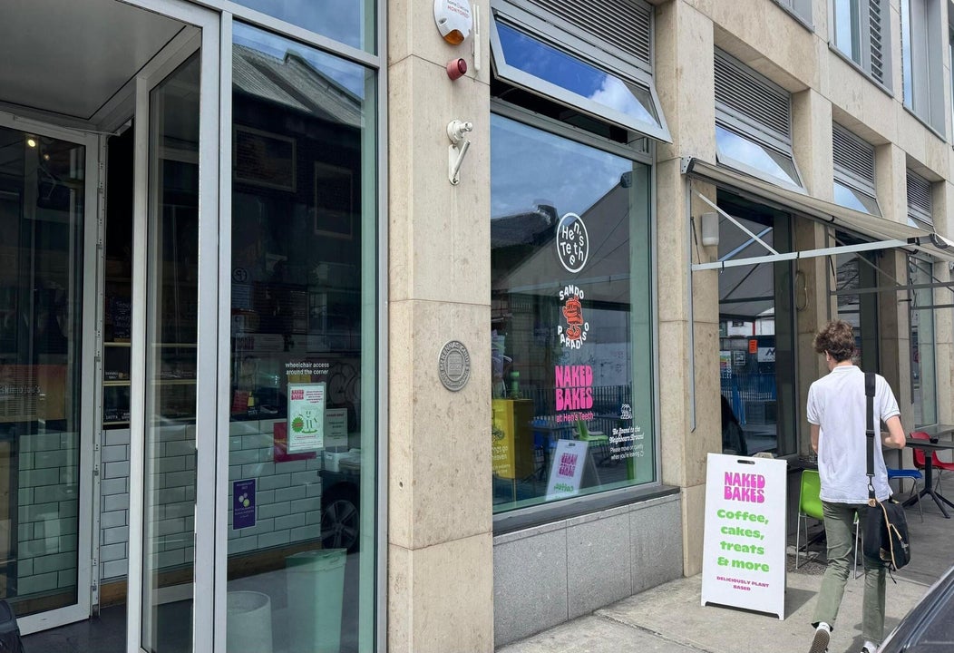 Exterior of a coffee shop with a sandwich board and a person outside