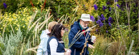 Three people walking in the gardens of Airfield Estate