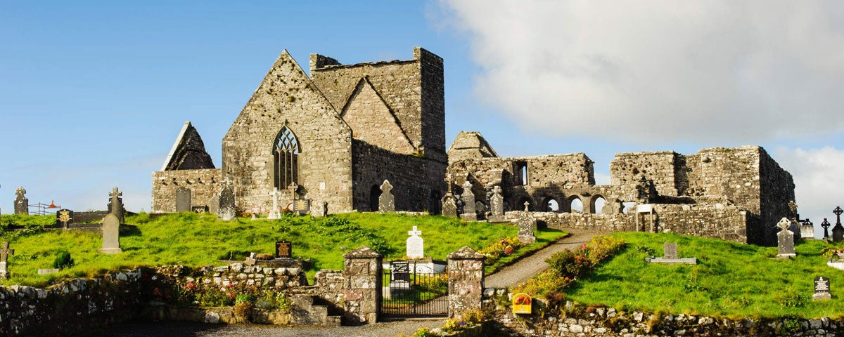 The ruins of an abbey overlooking a cemetery