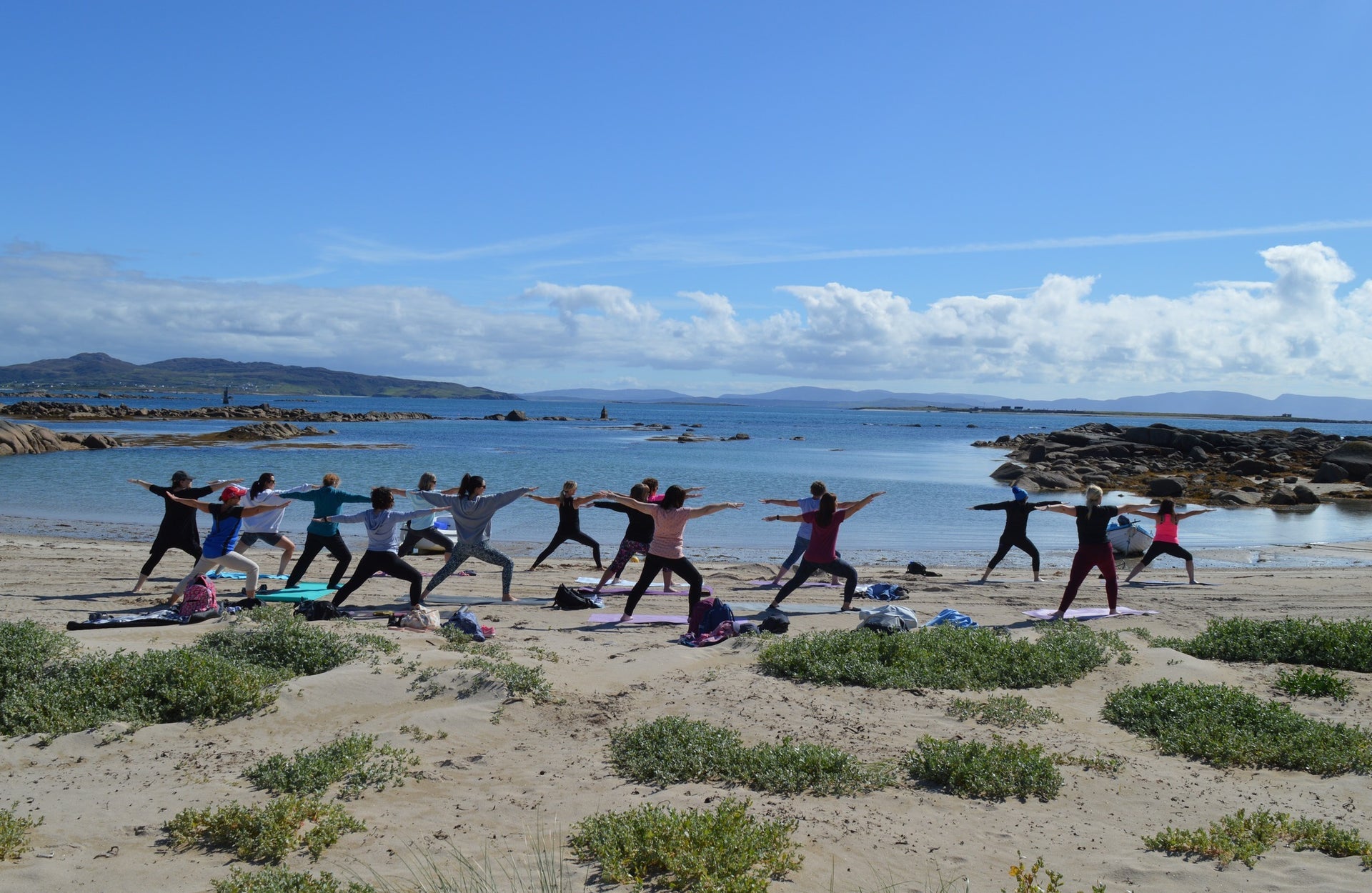 A group of people exercise on the beach