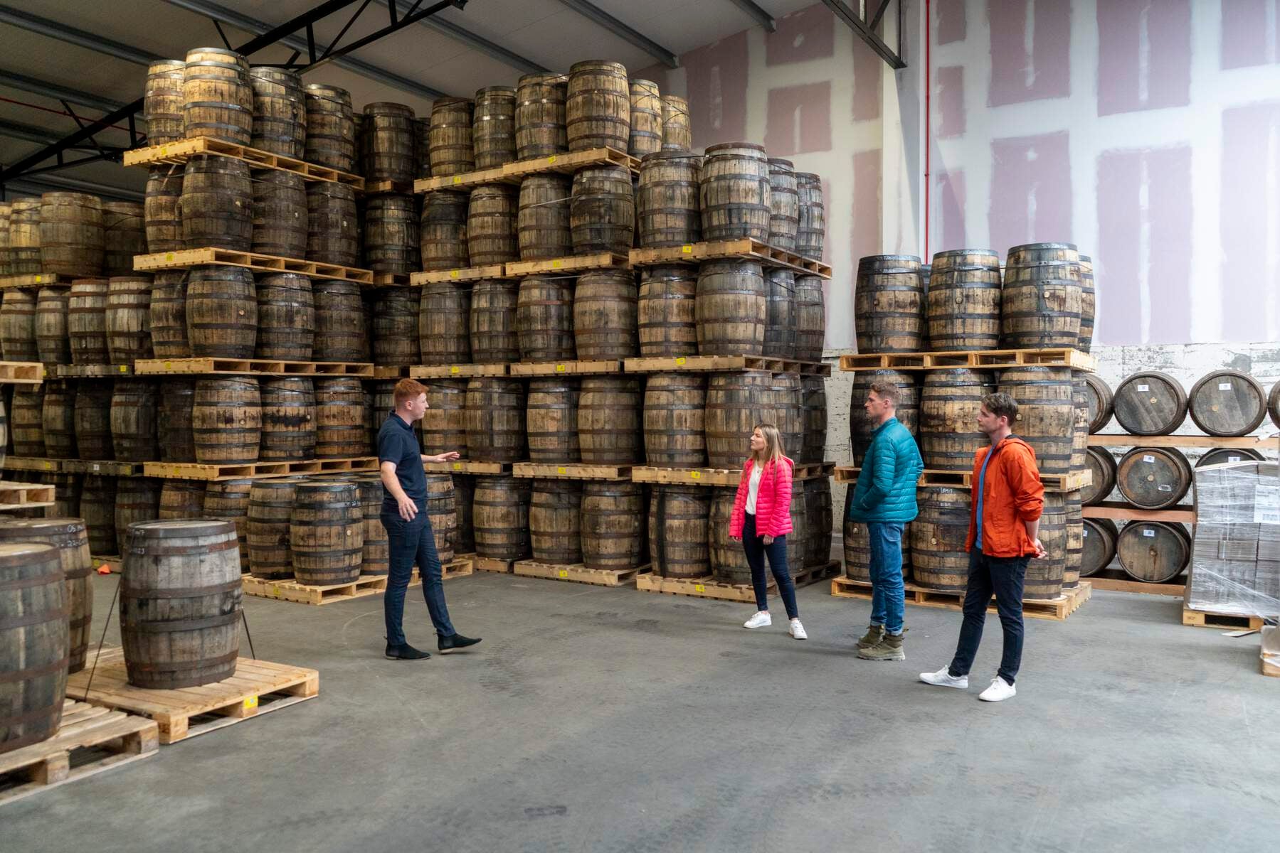 Inside the powerscourt distillery, picturing stacked barrels of whiskey.
