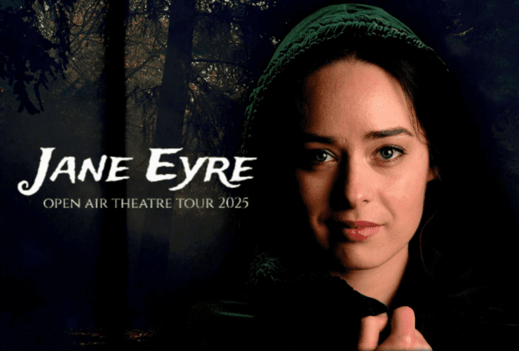 Face of a gently smiling woman wearing a dark bonnet against dark background of forest.