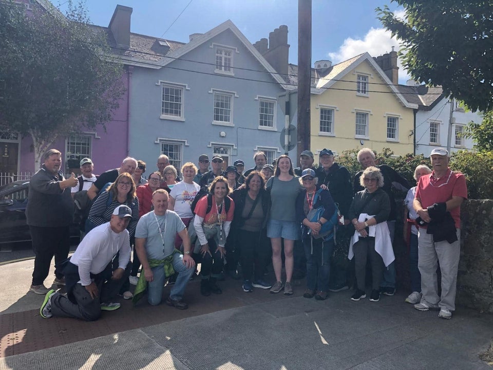 Group of people smiling for a photo in front of colourful buildings