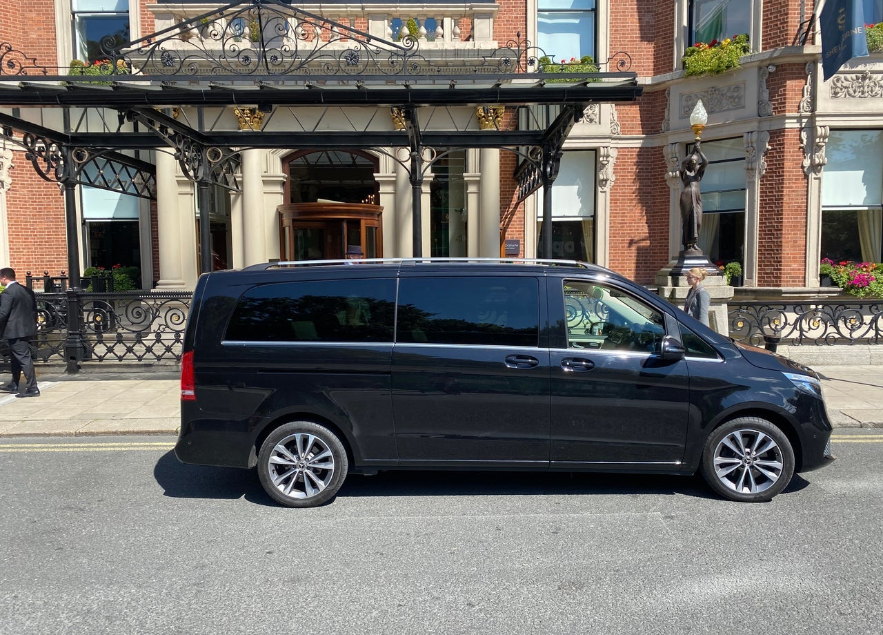 Luxury minivan parked at a hotel entrance