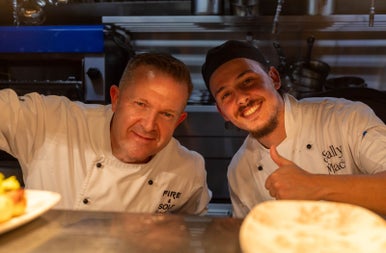 Two smiling chefs in a kitchen