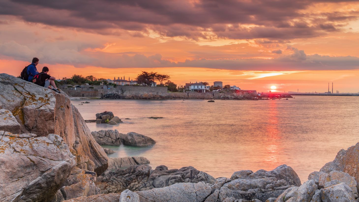 Two people sitting on a rock at Sandycove, Dublin