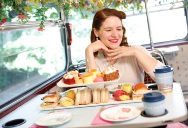 Passenger enjoying afternoon tea aboard a Vintage Tea Trips bus