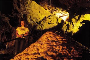 Person standing inside the cave at Crag Cave