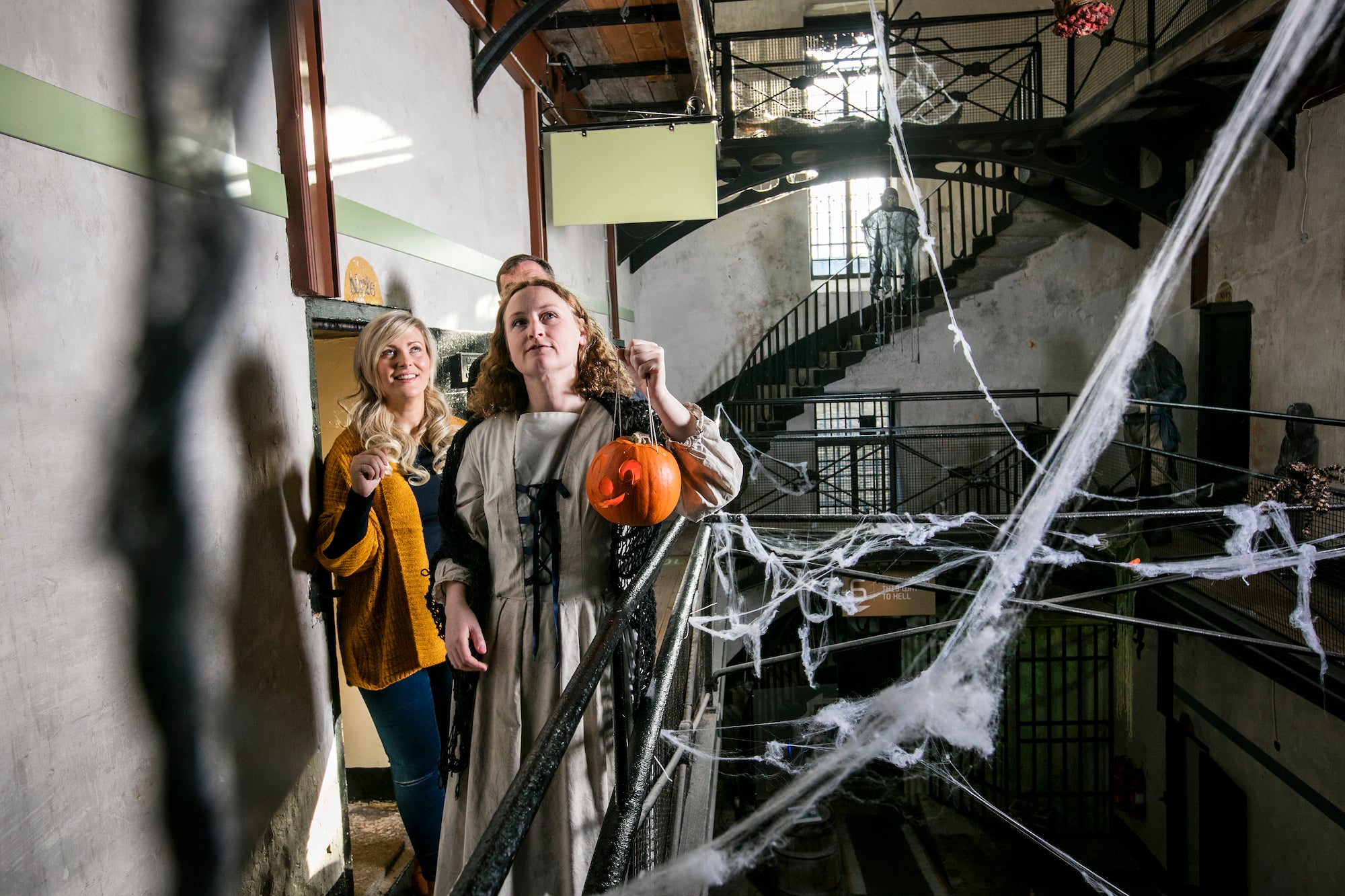 Three people on a Halloween tour through Wicklow Gaol.