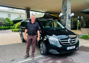 Aiden from Executive Explorer Luxury Tours standing beside a Mercedes luxury car