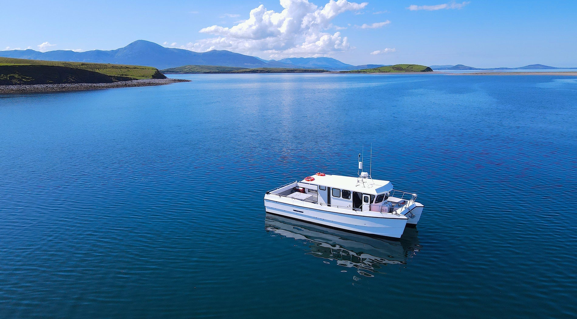 A small charter boat on a calm sea under a blue sky