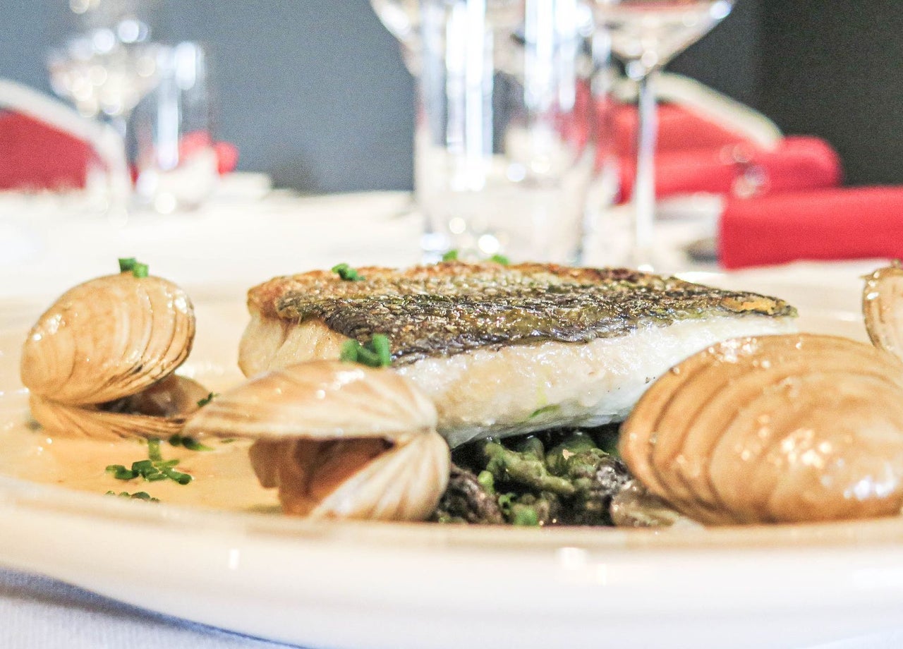A fillet of fish on a plate with clams