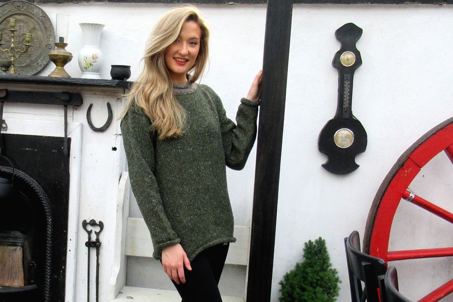 A lady standing and posing for the camera wearing a sweater from Tweed