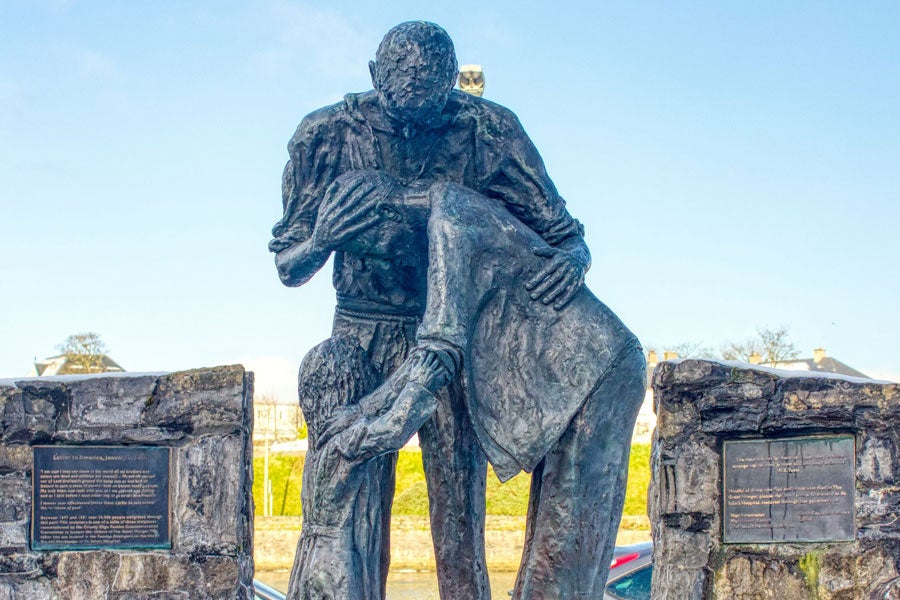 A statue of parents embracing a child in despair