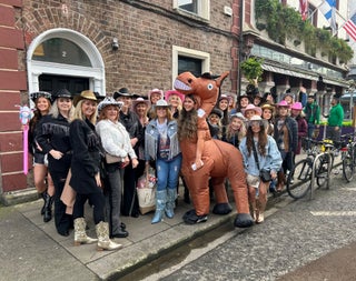 A large group in cowboy themed outfits on a city footpath