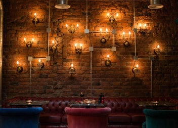 Exposed brick wall with vintage leather seating and warm wall lighting