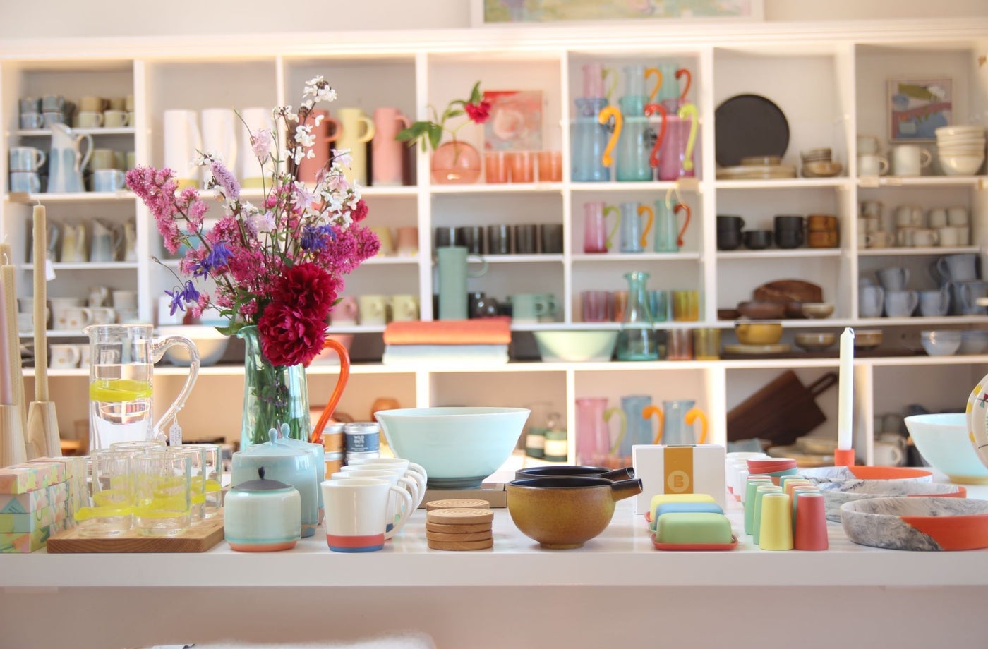 Counter and shelves in a shop full of colourful artisan ceramics