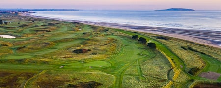 A view of a golf course with the sea in the background