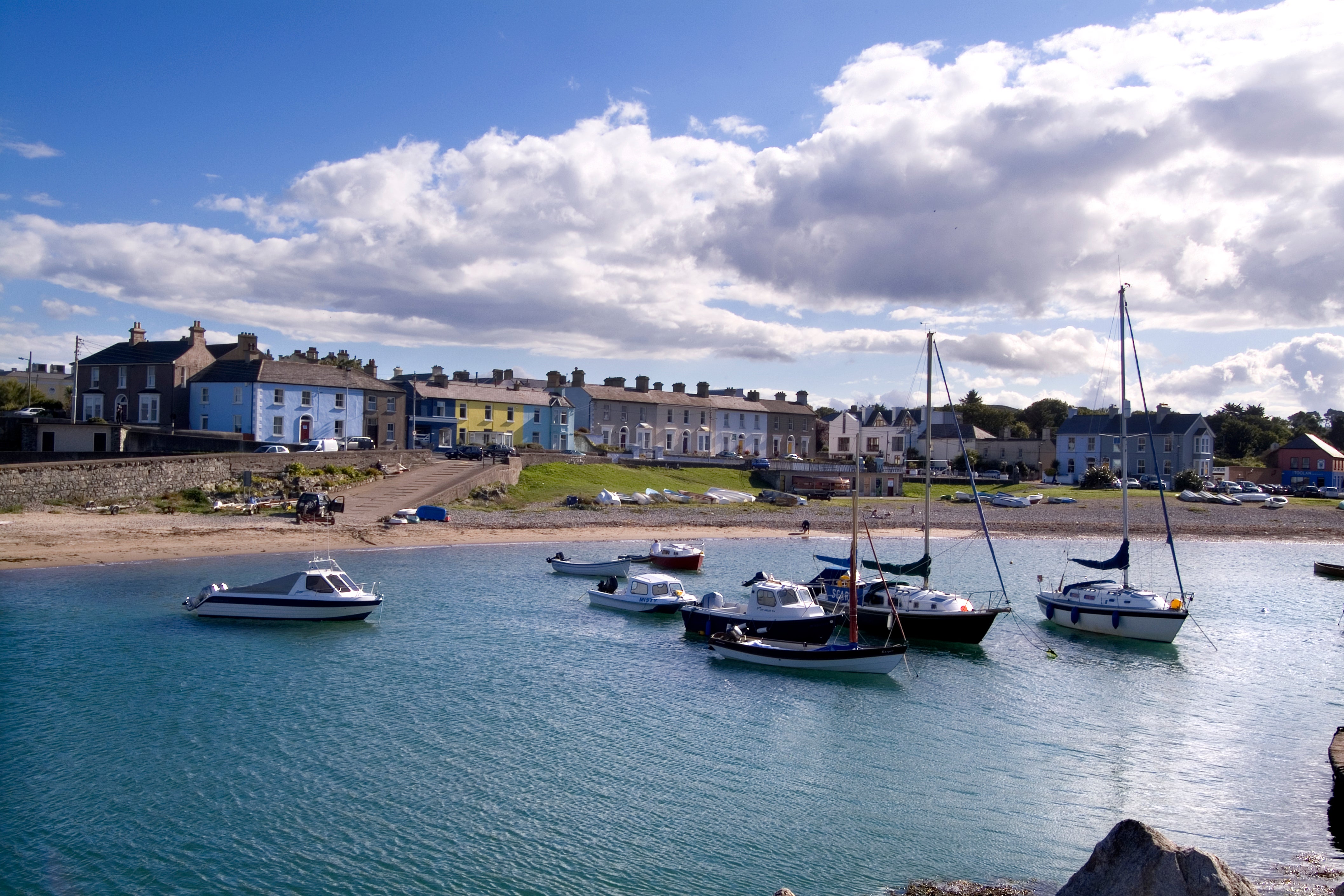 Boats on still waters at Greystones Harbour with a backdrop of colourful houses