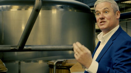 A guide explaining a process within a distillery