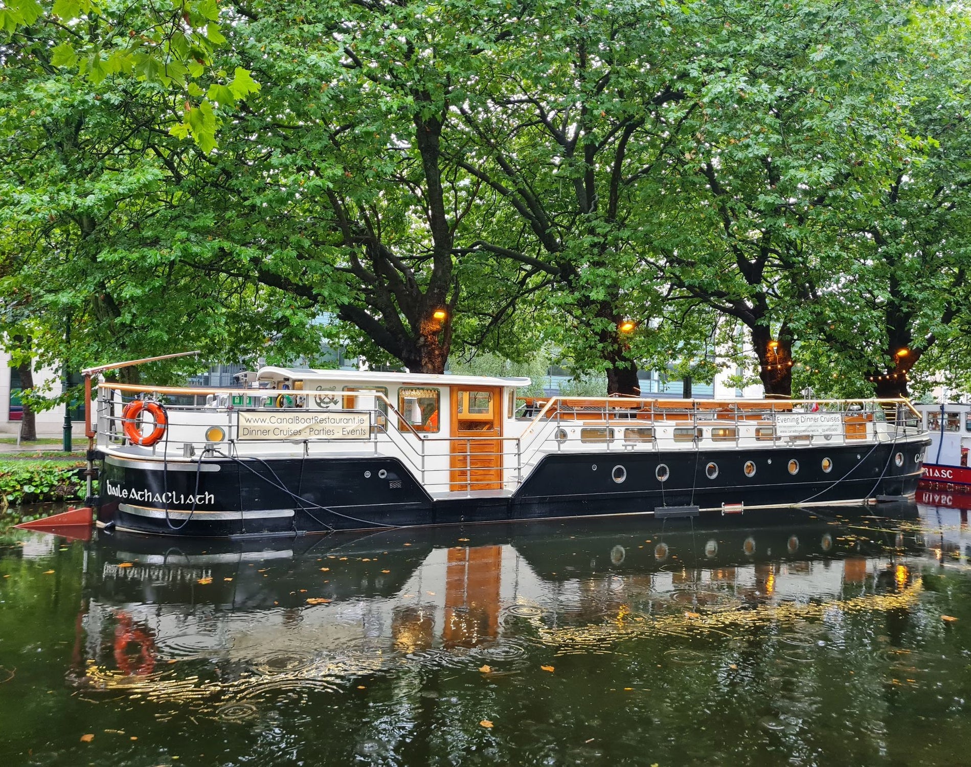 Canal barge moored on a tree lined section of a canal