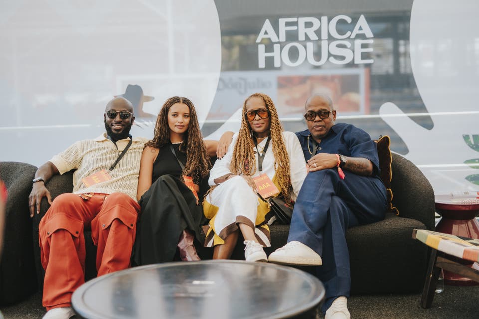 Group of diverse artists sitting together in front of Africa House banner